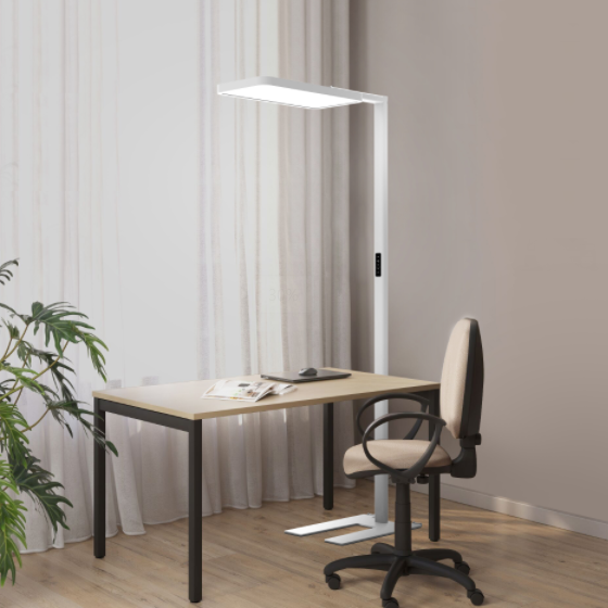 A white floor lamp beside a desk and office chair